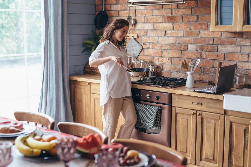 Femme dans la cuisine cuisinant dans une poêle