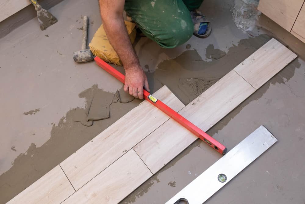 Un constructeur vérifie le niveau de surface des carreaux